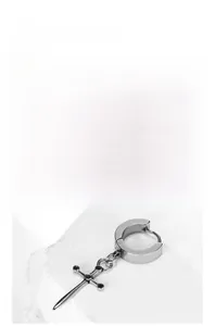 Detail of silver cross drop earring on white stone with minimalist punk design