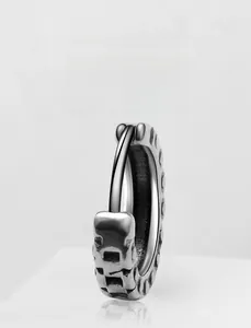 Macro view of vintage titanium steel earring with geometric etched texture and cool metal finish
