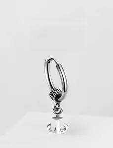 Close-up of silver steel hoop earring featuring a nautical anchor charm and meander bead