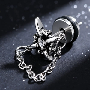 Detailed macro of stainless steel punk cross earring with zircon stone and fine chain