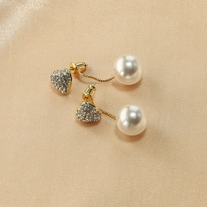Elegant gold drop earrings with diamond heart and large pearl on champagne silk