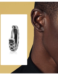 Close-up of vintage titanium steel hoop earring with embossed geometric square patterns