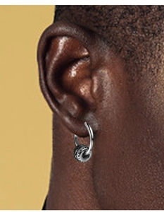 Gros plan de la boucle d'oreille hip hop argentée avec une perle texturée vintage