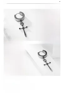 Macro shot of silver stainless steel cross earring with black stones and mirror finish