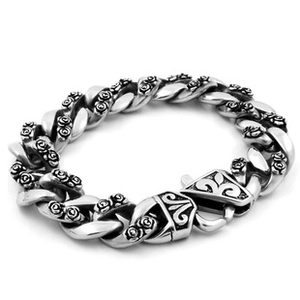 Macro view of vintage silver Cuban link bracelet featuring intricate rose floral relief