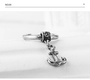 Macro shot of silver-tone stainless steel hoop earring with anchor pendant and textured details