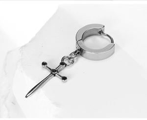Macro view of silver stainless steel huggie hoop earring with minimalist sword pendant