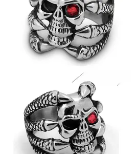 Macro shot of silver punk skull ring featuring a single red gemstone eye and claw detail