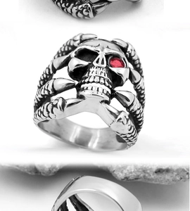 Macro detail of gothic skull ring featuring a red gemstone eye and punk steel bone texture