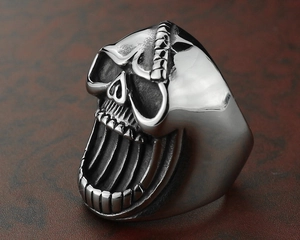 Macro view of skull bottle opener ring showing detailed punk grin and polished steel texture