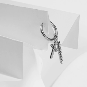Modern silver hoop earrings with hanging cross and curb chain charms on white background