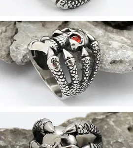 Detailed view of punk skeleton ring featuring red rhinestone eyes and eagle claw texture