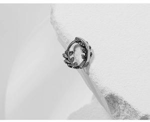 Detailed macro view of vintage silver ear cuff with oxidized vine leaf pattern design