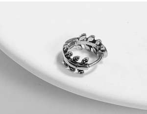 Close-up of vintage blackened steel earring featuring intricate leaf textures