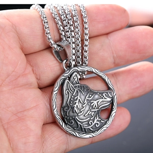 Collier pendentif loup nordique circulaire en acier inoxydable argenté sur main