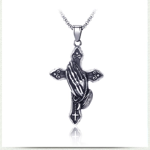 Vue détaillée du pendentif croix argent vintage avec mains en prière et chaîne à mailles