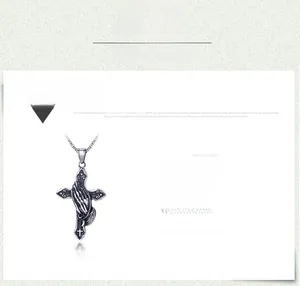 Détail du pendentif croix en acier titane argent antique avec mains en prière, 56x36mm