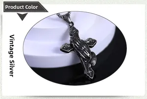 Détail macro du pendentif croix en argent antique avec motif de mains en prière