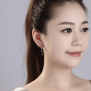 Silver stainless steel cross hoop earrings for women on a model for a vintage hip hop look