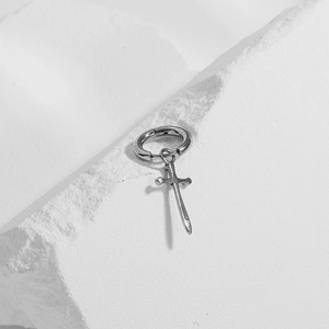 Retro stainless steel hoop earring with dagger pendant on white stone display