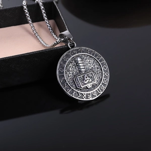 Macro shot of Viking Mjolnir medallion with runes on a textured black leather case
