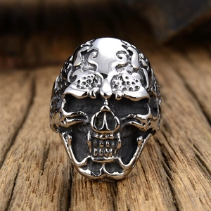 Vintage punk skull ring for men in oxidized metal finish on rustic wood background