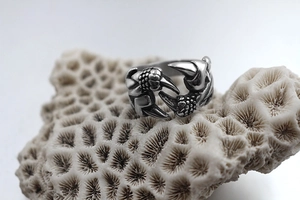 Close-up of vintage stainless steel dragon claw ring on natural coral stone