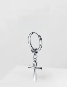 Macro detail of silver steel earring with a dangling Ankh symbol in punk style
