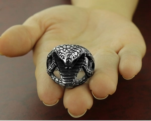 Macro detail of vintage stainless steel cobra ring showing realistic snake scale textures
