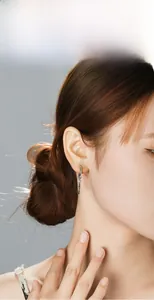 Silver cross pendant earring detail on model with stainless steel chain and minimalist hoop
