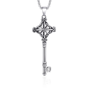 Polished stainless steel key pendant necklace with ornate cross cutout on white background