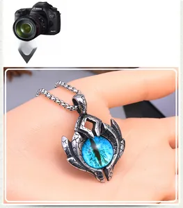 Macro shot of retro stainless steel evil eye pendant with blue core and flame details