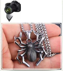 Detailed close-up of retro silver spider pendant with punk style textured metal finish