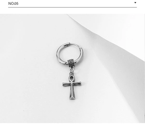Macro detail of silver stainless steel earring with Ankh cross and Greek key pattern