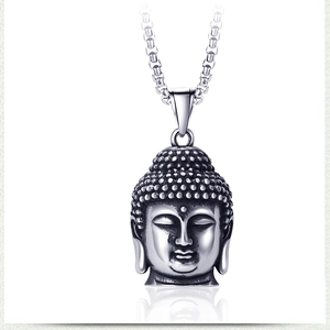Gros plan du pendentif tête de bouddha en argent vintage avec gravure et chaîne en acier