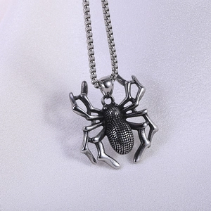 Gothic titanium steel spider pendant necklace with bead chain on purple fabric background