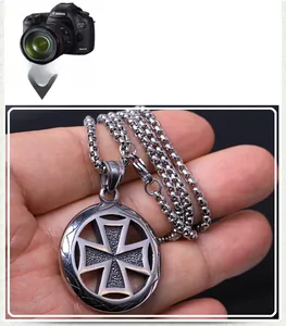 Detail of silver stainless steel iron cross pendant with hammered texture and round chain