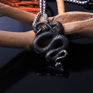 Detailed close-up of vintage snake pendant showing intricate scales on a wooden branch