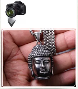 Vue détaillée du pendentif tête de bouddha argenté vieilli avec sa chaîne à gros maillons