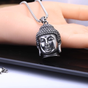 Détail macro du pendentif tête de Bouddha en acier inoxydable avec chaîne épaisse