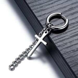 Close-up of punk style silver steel earring with cross pendant and link chain detail