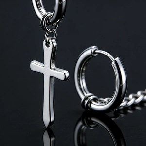 Polished silver cross drop earrings with chain detail on a reflective black surface