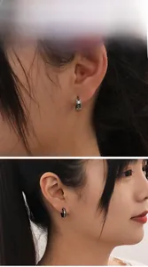 Gros plan de boucles d'oreilles créoles minimalistes en acier avec finition mate sablée