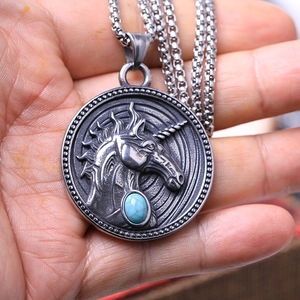 Détail macro d'un pendentif bouclier licorne vintage avec pierre turquoise et chaîne