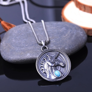 Collier bouclier licorne vintage avec gemme bleue sur fond de pierre naturelle grise
