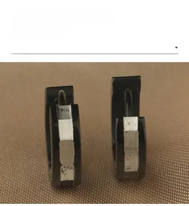 Vue rapprochée de boucles d'oreilles créoles en acier inoxydable noir et argenté