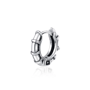 Detailed close-up of a silver vintage steel hoop earring with textured bamboo pattern