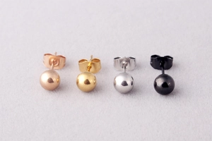 Close-up of titanium steel ball earrings in rose gold, gold, silver, and black finish