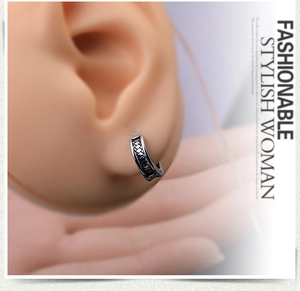 Macro view of vintage silver hoop earring with woven texture shown on ear model