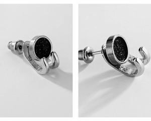 Macro detail of silver titanium steel earring with black shimmering frosted inlay